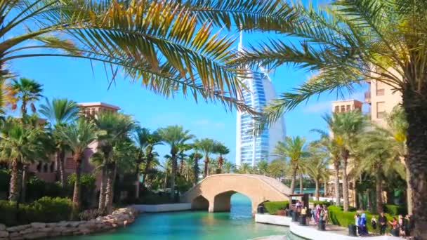 3月4日在迪拜 阿联酋迪拜 2020年3月4日 Souk Madinat Jumeirah市场和Burj Arab酒店的运河 风车通过棕榈树枝摇曳的景观 — 图库视频影像