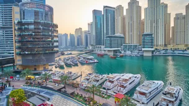 ドバイ アラブ首長国連邦 2020年3月2日 豪華な住宅高層ビル 近代的なホテルやレストランに囲まれたマリーナモールのヨットの上の黄金の夕日 ドバイで3月2日 — ストック動画