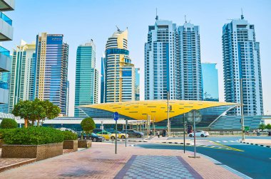 DUBAI, BAE - 2 Mart 2020 'de Dubai' deki Jumeirah Lake Towers kompleksinin önündeki Damac Emlak metro istasyonunun fütüristik ppavyonu
