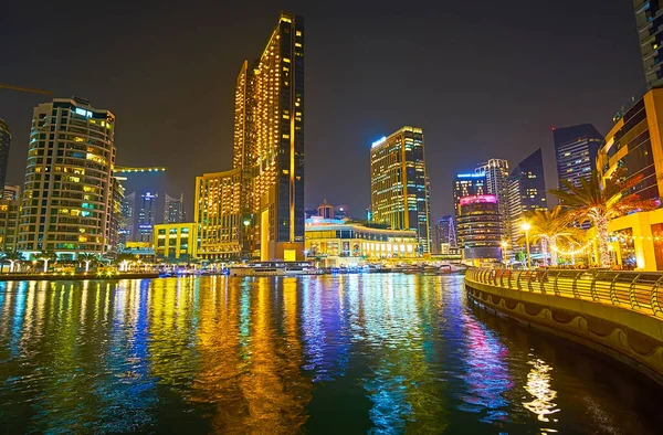 DUBAI, BAE - 2 Mart 2020: Dubai Marina 'da romantik bir akşam geçirin 2 Mart' ta Dubai 'de şehir ışıklarının, modern gökdelenlerin siluetlerinin ve karanlık sulardaki yansımalarının keyfini çıkarın