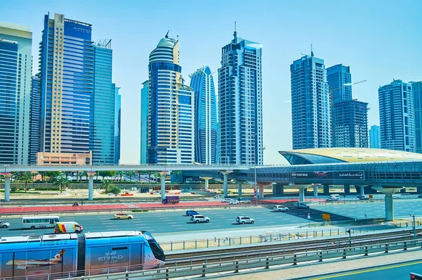 DUBAI, BAE - 2 Mart 2020 'de Dubai' deki Jumeirah Gölü Kuleleri 'nin önündeki metro istasyonunun önündeki hızlı trafiği, gökdeleni ve hızlı trafiği olan Şeyh Zayed yolu.