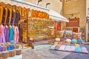 DUBAI, BAE - 2 Mart 2020: Dubai Grand Souq (Pazar, Pazar) tezgahı, Dubai 'de çeşitli renkli çömlekçilik, hediyelik eşya, yastık, ince işlemeli desenler ve Arapça giysiler ile 2 Mart' ta