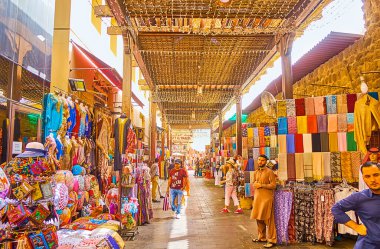 DUBAI, BAE - 2 Mart 2020: Dubai Grand Souq 'un dar sokağı (pazar, pazar), tezgahlarla kaplı, giysi, hediyelik eşya, kaşmir eşarp, nakışlı yastık kılıfları vs. 2 Mart' ta Dubai 'de
