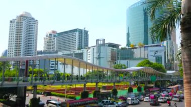 BANGKOK, THAILAND - 24 Nisan 2019: İnsanlar 24 Nisan 'da Bangkok' ta Ratchathewi ilçesinin alışveriş merkezleri ve iş merkezleri boyunca uzanan kalabalık Ratchadamri Yolu üzerinde gökyüzünde yürüyor