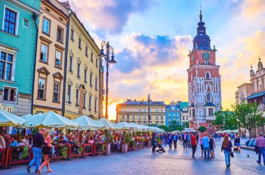 KRAKOW, POLAND - 12 Haziran 2018: Krakow 'da, tarihi yerler boyunca yürüyen turist kafeleri ve kalabalıkların bulunduğu Rynek Parlak Meydanı' nda akşam saatleri