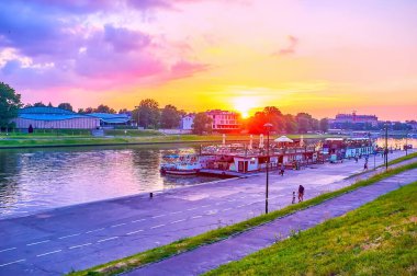 KRAKOW, POLAND - 12 Haziran 2018: Krakow 'daki Vistula Nehri üzerindeki alacakaranlıklar, 12 Haziran' da Krakow 'da kıyılara demirlemiş mavna-restoranlar