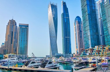 DUBAI, BAE - 2 Mart 2020 Dubai Marina 'nın en yüksek gökdelenlerinin önündeki yat kulübü - Cayan Kulesi ve Damac Residenze, 2 Mart' ta Dubai 'de