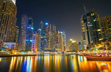 DUBAI, BAE - 2 Mart 2020: Dubai Marina 'nın karanlık sularında, fütüristik gökdelenlerle kaplı, renkli yansımasının tadını çıkarın, 2 Mart' ta Dubai 'de
