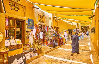 DUBAI, BAE - 2 Mart 2020: Al Fahidi ilçesi, 2 Mart 'ta Dubai' de Al Souq Al Kabir pazarının birçok mağazasına sahip, geleneksel çanak çömlek, kilim, Arapça kaligrafi ürünleri sunuyor.