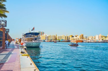 DUBAI, BAE - 2 Mart 2020: Al Fahidi ilçesi kıyısı boyunca yürüyün ve Dubai deresi boyunca 2 Mart 'ta yüzen abra ve dhow teknelerini izleyin