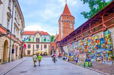 KRAKOW, POLAND - 12 Haziran 2018: Eski Krakow 'daki turistler, 12 Haziran' da Krakow 'daki St. Florian Kapısı' ndaki ünlü sanat eserlerinin keyfini çıkarıyorlar.