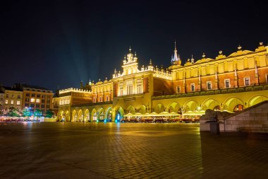 Ana Pazar Meydanı boyunca gece yürüyüşü ve Sukiennice ve etrafındaki evlerin muhteşem aydınlanmasını izlemek, Krakow, Polonya