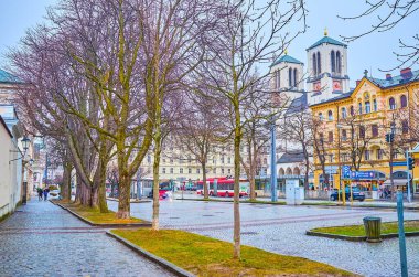 SALZBURG, AUSTRIA - 1 Mart 2019: Mirabellplatz 'daki St. Andrew Kilisesi' nin yüksek çan kuleleri, 1 Mart 'ta Salzburg' daki eski kasaba evlerinin üzerine yükselir.