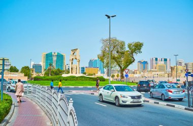 DUBAI, BAE - 2 Mart 2020: Dubai 'de Al Fahidi kavşağında heykel kompozisyonu ve yeşil çimlerle süslenmiş hızlı trafik