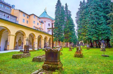 SALZBURG, AUSTRIA - 1 Mart 2019: 1 Mart 'ta Salzburg' da St Sebastian Mezarlığı 'nın karışık mezarları ve yüksek kozalaklı ağaçları olan küçük mezarlığı