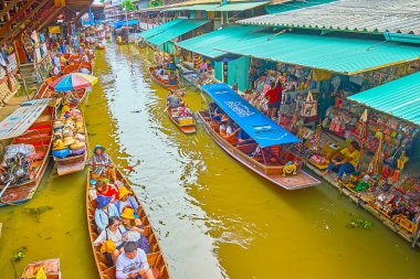 DAMNOEN SADUAK, THAILAND - 13 Mayıs 2019: Yüzen pazar faaliyetlerini izleyin, turistler khlong (kanal) üzerinde kayıkla geziyorlar ve Damnoen Saduak 'ta 13 Mayıs' ta yiyecek ve hediyelik eşya alışverişi yapıyorlar.