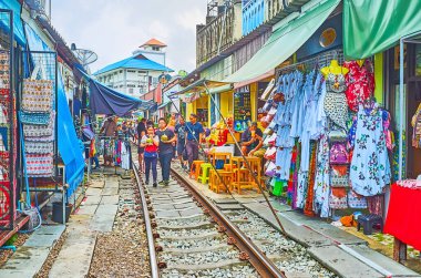 MAEKLONG, THAILAND - 13 Mayıs 2019: Turistler 13 Mayıs 'ta Maeklong Demiryolu Pazarı' nda, giysi, yiyecek ve hediyelik eşya tezgahlarıyla dolu olarak yürüyorlar.