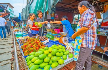 MAEKLONG, THAILAND - 13 Mayıs 2019: Maeklong Demiryolu Marketi 'nin çiftçi tezgahı, 13 Mayıs' ta Maeklong 'da meyvelerin arasında oynayan papaya, rambutan, mangosteen ve kedi yavrularıyla dolu.