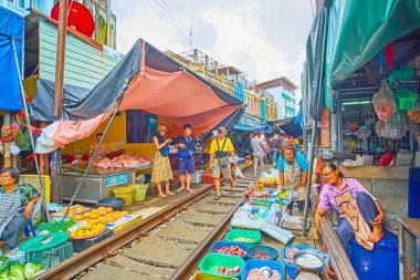MAEKLONG, THAILAND - 13 Mayıs 2019: Maeklong Demiryolu Pazarı 13 Mayıs 'ta Maeklong' da turistler arasında popüler olup, trene binmek ve egzotik yerlerde alışveriş yapmak için ziyaret etmektedir.