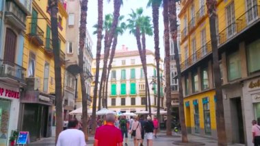 MALAGA, İspanya - 28 Eylül 2019: 28 Eylül 'de Malaga' da insanlar gölgeli Calle Puerta del MAr caddesinde uzun palmiye ağaçları, klasik yapılar ve birçok mağazayla yürür.