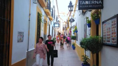 CORDOBA, SPAIN - 30 Eylül 2019: 30 Eylül 'de Cordoba' da tarihi evler ve sayısız hediyelik eşya dükkanı ve restoranlarla dolu dar Calle Cespedes 'te yürüyün