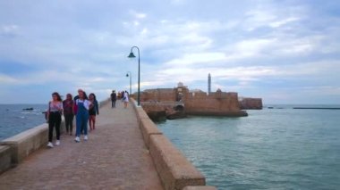 CADIZ, SPAIN - 21 Eylül 2019: 21 Eylül 'de Cadiz' de küçük bir adada bulunan ve Atlantik Okyanusu 'nun sularıyla çevrili Castillo San Sebastian' a giden dar taş geçidi