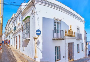 ARCOS, SPAIN - 23 Eylül 2019: 23 Eylül 'de Arcos' ta, Pueblo Blanco 'nun dar tepe sokağında bulunan ve oyulmuş taş arma ile süslenmiş ortaçağ beyaz köşkünde yürüyün.