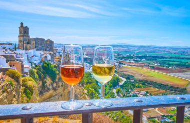 Enjoy the glass of Sherry wine with a view on medieval white town (pueblo blanco) of Arcos, located on the cliff top and famous for its unique medieval architecture, Spain clipart