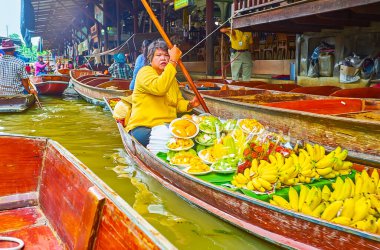 DAMNOEN SADUAK, THAILAND - 13 Mayıs 2019: 13 Mayıs 'ta Damnoen Saduak' taki Ton Khem yüzer pazarında içinde bir paket mango, rambutan, elma ve muz bulunan sote besin botu yüzüyor