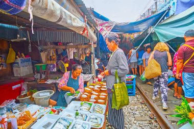 MAEKLONG, THAILAND - 13 Mayıs 2019: Maeklong Demiryolu Pazarı 'nın tezgahı (Talad Rom Hoop) 13 Mayıs' ta Maeklong 'da içi uskumru dolu bambu vapurlarıyla
