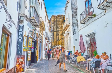 ARCOS, SPAIN - 23 Eylül 2019: Pueblo Blanco 'nun dar Dean Espinosa sokağı (beyaz kasaba) 23 Eylül' de Arcos 'ta küçük samimi turistik kafeler ve barlarla doludur.