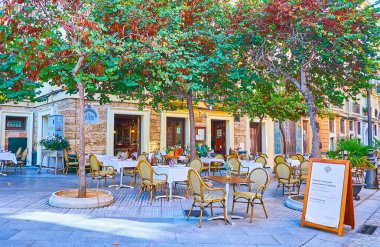 CADIZ, İspanya - 23 Eylül 2019 'da Cadiz' de, Calle Plocia caddesinin gölgeli ağaçlarının altında küçük masalı restoranın rahat açık hava terası