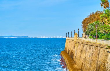 Okyanus kıyısında yürüyün ve İspanya 'nın Costa de la Luz bölgesindeki Paseo de Carlos bahçesinin kaleleri, bekçi kuleleri, eski fenerleri ve yemyeşil bahçeleriyle Cadiz Kalesi' nin devasa surlarını gözlemleyin.
