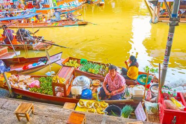 DAMNOEN SADUAK, THAILAND - 13 Mayıs 2019 Damnoen Saduak yüzen pazarında, üzerinde muz, mango ve muz yaprağı demetleri bulunan meyve tedarikçilerinin tekneleri, 13 Mayıs 'ta Damnoen Saduak' ta
