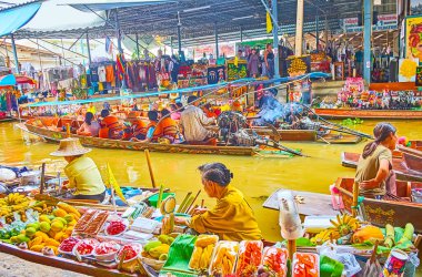 DAMNOEN SADUAK, THAILAND - 13 Mayıs 2019: Örnek tekne Damnoen Saduak yüzen pazarında, 13 Mayıs 'ta, çeşitli egzotik meyveler sunan meyve satıcısı için vitrin ve tezgah görevi görür.