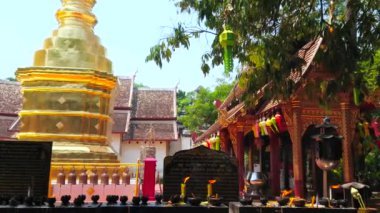 CHIANG MAI, THAILAND - 2 Mayıs 2019: 2 Mayıs 'ta Chiang Mai' de, Wat Phra Singh tapınağının küçük altın çadırı ve süslü mondop köşkünde yanan mumlar ve ruhlarla sunak