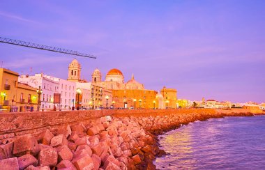 CADIZ, İspanya - 23 Eylül 2019: Tarihi Katedral ile alacakaranlık silueti, eski evlerin ve tarihi kale duvarlarının üzerinde yükseliyor, 23 Eylül 'de Cadiz' de