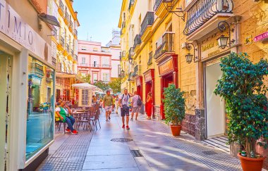 CADIZ, SPAIN - 23 Eylül 2019: 23 Eylül 'de Cadiz' de açık kafe, mağazalar, klasik yapılar ve çömleklerle dolu kalabalık Calle Columela caddesi