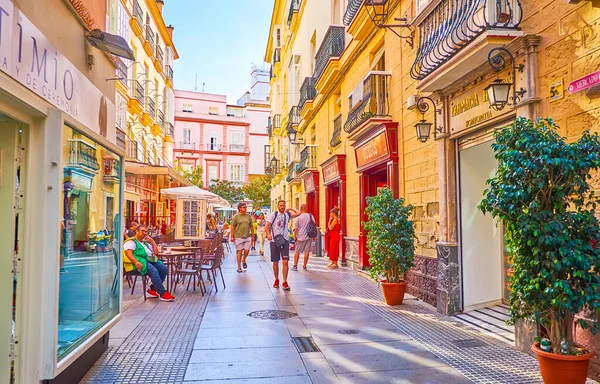CADIZ, SPAIN - 23 Eylül 2019: 23 Eylül 'de Cadiz' de açık kafe, mağazalar, klasik yapılar ve çömleklerle dolu kalabalık Calle Columela caddesi
