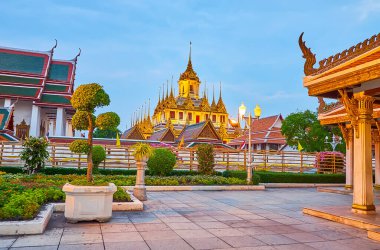 Loha Prasat 'ın Wat Ratchanatdaram kompleksinin manzaralı binasını karartan loş ışıklar, Bangkok, Tayland' daki Mahajetsadabadin parkından görülüyor.