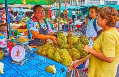BANGKOK, THAILAND - 13 Mayıs 2019: Satıcı, 13 Mayıs 'ta Bangkok' ta Mahanak meyve pazarındaki müşterilerine taze durian sunuyor.