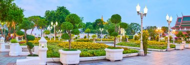 Süslü Mahajetsadabadin parkının akşam manzarası saksılarda ağaç ağaçları, kadife çiçekleri, eski fenerler ve asılı orkideler, Bangkok, Tayland