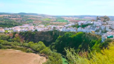 İspanya 'nın Sierra de Cadiz kentindeki sarı tarlaları ve çayırları olan Arcos' un ortaçağ beyaz kasabası (pueblo blanco) ile kaplı dik kayalar.