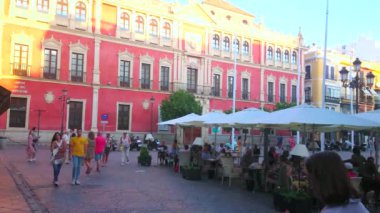 SEVILLE, SPAIN - 1 Ekim 2019: Arka planda 1 Ekim 'de Seville' de, açık kafelerin masaları ve güneşli gölgeleriyle kalabalık San Francisco meydanı