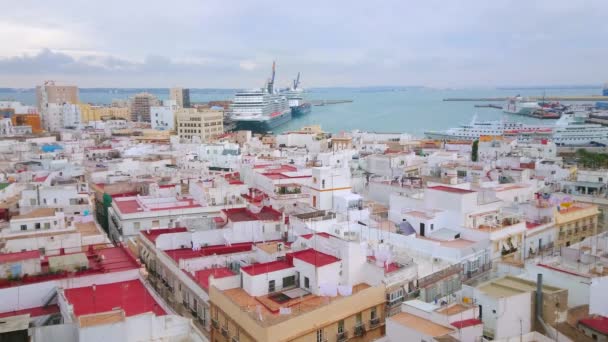 住宅街の景色を望む旧市街の密集した住宅 赤い屋根と背景にクルーズライナーを持つカディス港 コスタ スペイン — ストック動画