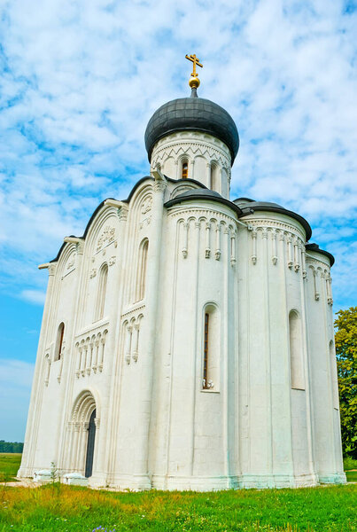 The carved medieval Church of the Intercession on Nerl river with onion dome, slender wall columns, reliefs and wall sculptures, Bogolyubovo, Russia
