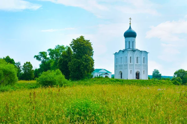 The Church of the Intercession on Nerl river is surrounded with juicy green meadows and lush trees, Bogolyubovo, Russia — Stock Image Church Intercession Nerl River Surrounded Juicy Green Meadows Lush Trees Royalty Free Stock Images