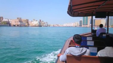 DUBAI, BAE - 8 Mart 2020: Dubai Deresi 'nde 8 Mart' ta Dubai 'de tarihi Al Fahidi, Bur Dubai ve Deira distircts ve geleneksel kerpiç evleri (pazarlar) ile çevrili hızlı feribot yüzüyor.
