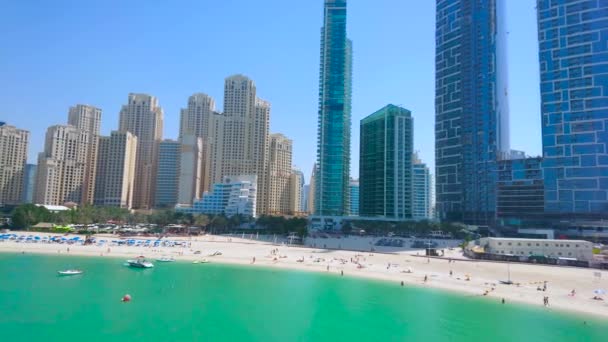 ドバイ アラブ首長国連邦 2020年3月7日 ドバイで3月7日に ビーチやガラスの高層ビルでホリデーメーカー ヨット 遊覧船と混雑したJbrマリーナビーチのパノラマ — ストック動画