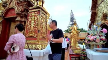 CHIANG MAI, THAILAND - 7 Mayıs 2019: Budist fanatikler 7 Mayıs 'ta Chiang Mai' deki Doi Suthep tapınağında Wat Phra 'nın süslü altın çadırı etrafında yürürler.